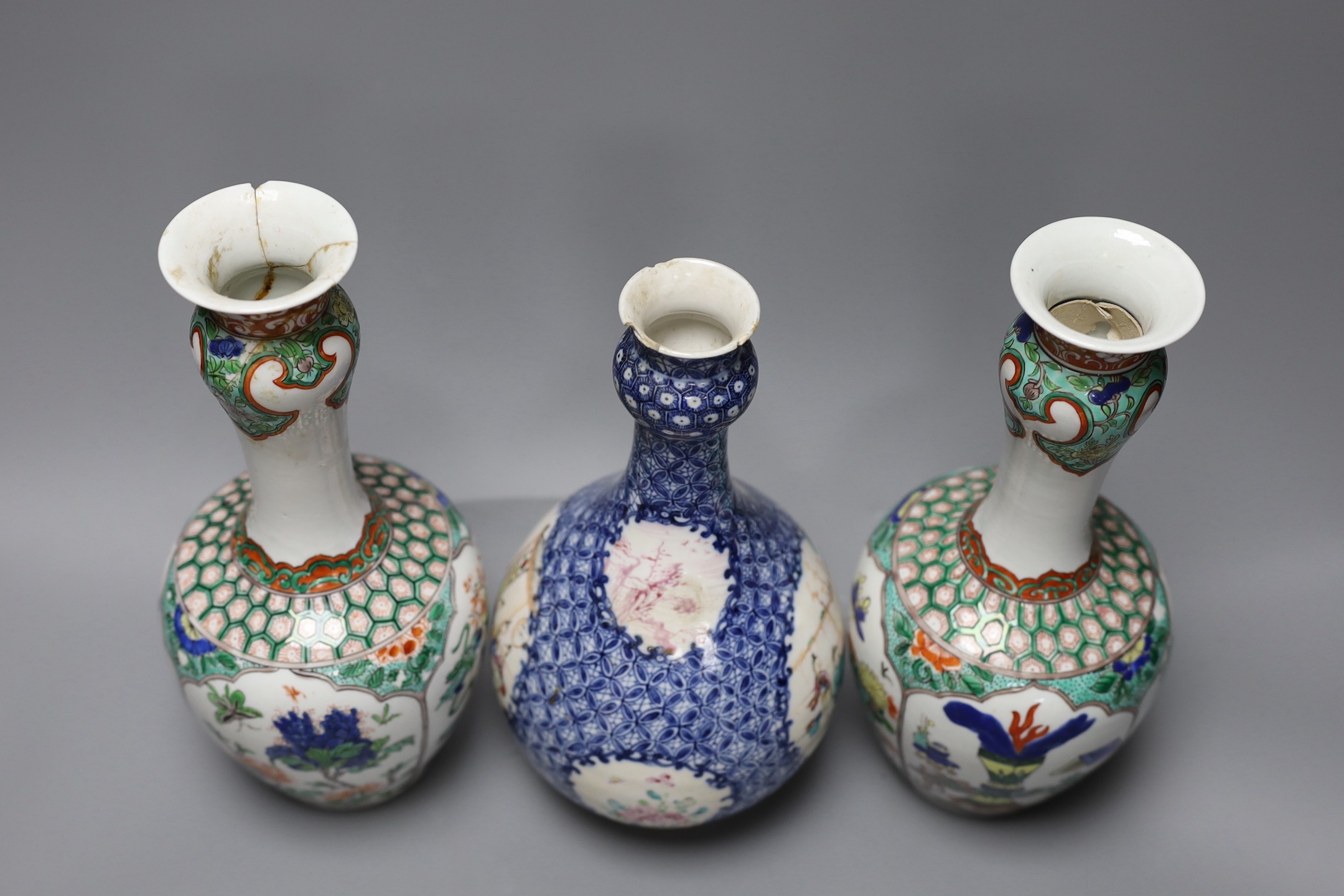 A pair Samson of Paris vases in the Chinese famille verte style and a Chinese Qianlong famille rose garlic neck vase with blue panelling motif, tallest 26cm